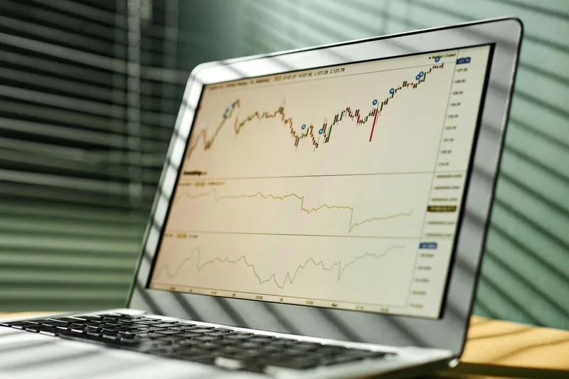 Imagem ilustrativa de gráficos financeiros na tela de um notebook